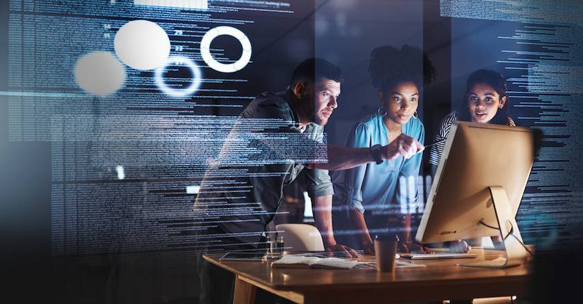 Taking on the late shift with true dedication Shot of a group of programmers working together on a computer code at night