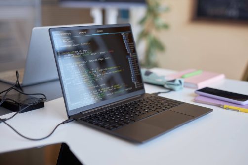 laptop-with-codes-on-screen-standing-on-desk-of-hi-2023-11-27-05-27-43-utc (1)